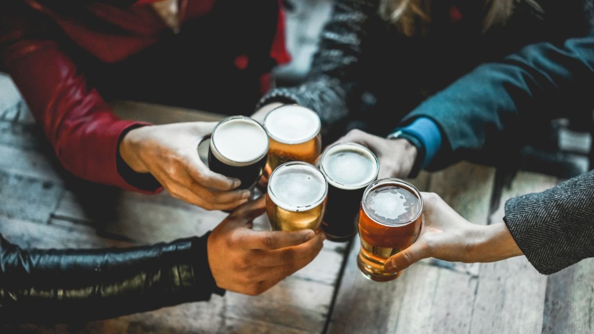 Friends holding beers and cheersing