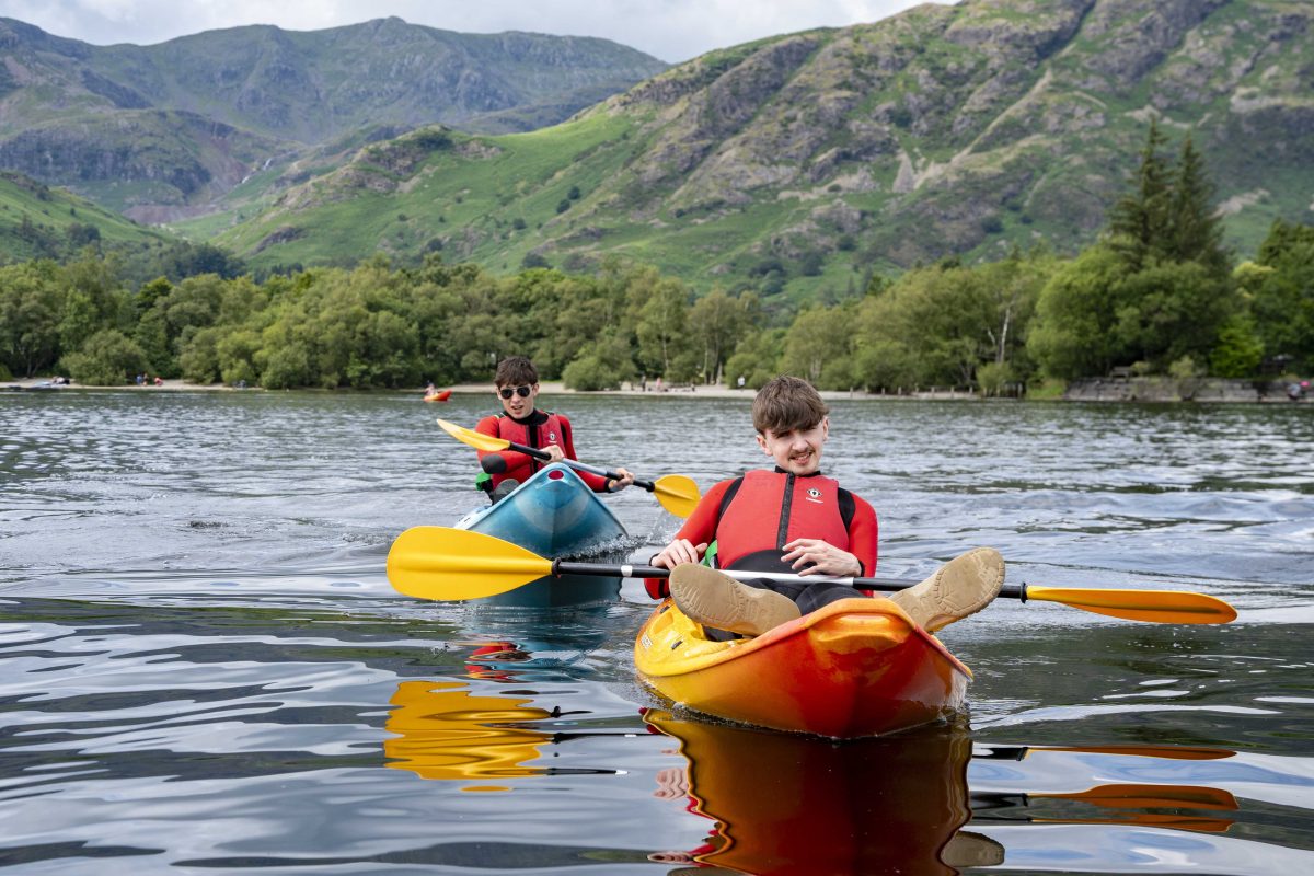 Two children on kayaks in Coniston water near Torver