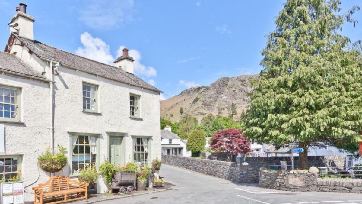 View of the Coppermines 'the old post cottage' (Bridge Cottages) with Coniston fells in the background
