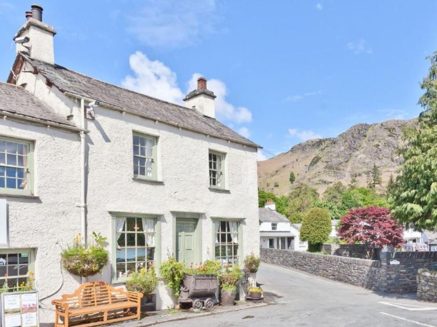 View of the Coppermines 'the old post cottage' (Bridge Cottages) with Coniston fells in the background